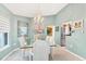 Charming dining room with chandelier, large windows, and seating for six near the kitchen at 109 Southampton N Pl # 245, Venice, FL 34293