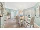 Charming dining room with chandelier, large windows, and seating for six near the living room at 109 Southampton N Pl # 245, Venice, FL 34293
