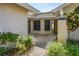 Welcoming entrance with tiled walkway and front door, adorned by manicured landscaping and stylish exterior details at 109 Southampton N Pl # 245, Venice, FL 34293