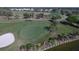 Scenic view of a well-manicured golf course green with a sand trap and waterside landscaping at 109 Southampton N Pl # 245, Venice, FL 34293