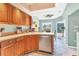 Bright kitchen featuring wooden cabinets, stainless steel appliances, and view of the breakfast nook at 109 Southampton N Pl # 245, Venice, FL 34293
