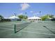 Outdoor tennis courts featuring a green playing surface, nets, and manicured landscaping in a vibrant community setting at 109 Southampton N Pl # 245, Venice, FL 34293