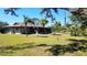 Expansive backyard with lush greenery, mature palm trees, and serene natural surroundings at 1110 Gladstone Blvd, Englewood, FL 34223
