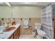 The bathroom is equipped with a large vanity, toilet, and shower with a tiled wall at 1110 Gladstone Blvd, Englewood, FL 34223