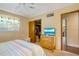 Comfortable bedroom with a ceiling fan, dresser with TV, and closet storage space at 1110 Gladstone Blvd, Englewood, FL 34223