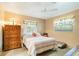 Cozy bedroom with a ceiling fan, comfortable bed, and natural light from the window with bird curtains at 1110 Gladstone Blvd, Englewood, FL 34223