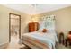 Comfortable bedroom featuring a ceiling fan, wooden dresser, and ensuite bathroom with a tiled floor at 1110 Gladstone Blvd, Englewood, FL 34223
