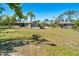 Single-story home with a detached garage, mature landscaping, and expansive backyard space at 1110 Gladstone Blvd, Englewood, FL 34223