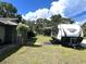 Beautiful lot featuring an RV with awning on lush green lawn, near a home and flowering tree at 1110 Gladstone Blvd, Englewood, FL 34223