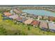 Aerial view of homes in a community with a beautiful lake and lush green landscaping at 11655 Renaissance Blvd, Venice, FL 34293