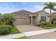 Charming single-story home with a well-manicured lawn, beautiful landscaping, and a brick driveway at 11655 Renaissance Blvd, Venice, FL 34293