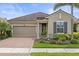 Charming home featuring a tile roof, brick driveway, manicured landscaping, and a two-car garage at 11655 Renaissance Blvd, Venice, FL 34293