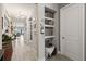 Hallway features wood-look tile floor, decorative niche, and doorways to various rooms at 11655 Renaissance Blvd, Venice, FL 34293