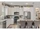 Bright kitchen featuring stainless steel appliances, granite countertops, and a large island with seating at 11655 Renaissance Blvd, Venice, FL 34293