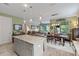 Bright open space with a kitchen island, dining table, and view to the living room and outdoor space at 11655 Renaissance Blvd, Venice, FL 34293