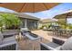 Outdoor patio with stylish seating, umbrella, and manicured landscaping, ideal for outdoor gatherings at 11655 Renaissance Blvd, Venice, FL 34293