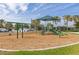 Outdoor playground area with mature trees, swings, slides, and a jungle gym for community families at 11655 Renaissance Blvd, Venice, FL 34293