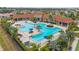 An aerial view showcases a resort-style pool, a sun deck, and tropical landscaping at the community clubhouse at 11655 Renaissance Blvd, Venice, FL 34293