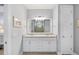 Well-lit bathroom with a double vanity, granite countertops, and a large mirror, offering plenty of space at 13032 Oriago St, Venice, FL 34293