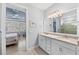 En-suite bathroom featuring a double vanity that leads to the main bedroom with beautiful natural lighting at 13032 Oriago St, Venice, FL 34293
