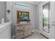 Foyer with decorative cabinet and adorned painting by a leaded glass entry door at 13032 Oriago St, Venice, FL 34293