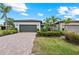 A beautiful single-Gathering home showcasing a manicured lawn and a brick-paved driveway at 13032 Oriago St, Venice, FL 34293