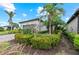 Landscaped front yard with colorful flowers and palm trees at 13032 Oriago St, Venice, FL 34293