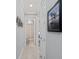 Hallway leading to a bathroom that features a shower and toilet and a picture hanging on the wall at 13032 Oriago St, Venice, FL 34293