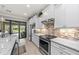 Well-equipped kitchen with stainless steel appliances, granite countertops, and access to outdoor living space at 13032 Oriago St, Venice, FL 34293