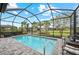A crystal-clear pool within a screened lanai provides a serene oasis with picturesque backyard scenery at 13032 Oriago St, Venice, FL 34293