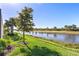 Beautiful backyard with a lake view, palm trees, and lush grass, perfect for enjoying the outdoors at 13251 Borrego St, Venice, FL 34293