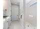 Clean bathroom with tiled walk-in shower, white cabinets, dark hardware, and marble floors at 13251 Borrego St, Venice, FL 34293