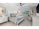 A primary bedroom with a tray ceiling, a ceiling fan, a window with shutters, and coastal decor at 13251 Borrego St, Venice, FL 34293