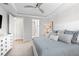 A view of a bedroom showcasing a large bed, ceiling fan, and access to a bathroom and closet at 13251 Borrego St, Venice, FL 34293