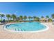 Large luxurious community pool with plenty of lounge chairs and umbrellas surrounded by palm trees at 13251 Borrego St, Venice, FL 34293