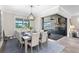 Dining room with a gray table, chairs, pendant lighting, and sliding glass doors to an outdoor kitchen at 13251 Borrego St, Venice, FL 34293