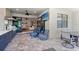 Relaxing outdoor living space featuring a full kitchen, comfortable striped chairs, and a view of the home's interior at 13251 Borrego St, Venice, FL 34293