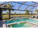 Stunning pool and spa with serene lake view, surrounded by lush landscaping and swaying palm trees at 13251 Borrego St, Venice, FL 34293