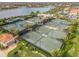 Aerial view of well-maintained tennis courts surrounded by lush landscaping and nearby lake at 13251 Borrego St, Venice, FL 34293