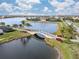 Scenic water view featuring a picturesque bridge, lush landscaping, and tranquil lake in a beautiful residential community at 13251 Borrego St, Venice, FL 34293
