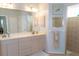 Bright bathroom featuring a double vanity, framed mirrors, and tiled walk-in shower at 14 Windward Ter, Placida, FL 33946