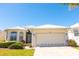 Exterior elevation of home with a two car garage, well manicured landscaping, and bright blue sky at 14 Windward Ter, Placida, FL 33946