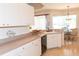 The updated kitchen features white cabinetry, tile flooring, and a breakfast nook at 14 Windward Ter, Placida, FL 33946
