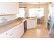 The updated kitchen features white cabinetry, tile flooring, and a breakfast nook at 14 Windward Ter, Placida, FL 33946