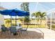 Screened patio featuring brick flooring, outdoor furniture, and views of the lush backyard at 14 Windward Ter, Placida, FL 33946