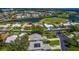 Aerial view of homes and neighborhood with golf course and lake views from above at 1400 Colony Pl, Venice, FL 34292