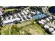 Aerial view of the community showcasing the clubhouse, golf course, pools, tennis courts, and parking areas at 1400 Colony Pl, Venice, FL 34292