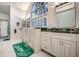 Bright bathroom featuring a walk-in tub, double sink vanity, and large window at 1400 Colony Pl, Venice, FL 34292