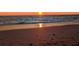 A serene beach scene featuring a golden sunset over calm waters at 1400 Colony Pl, Venice, FL 34292