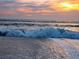 Picturesque view of waves crashing on a sandy beach during a vibrant sunset at 1400 Colony Pl, Venice, FL 34292